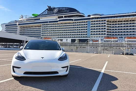 Tesla blanche vue de face devant un paquebot à quai.